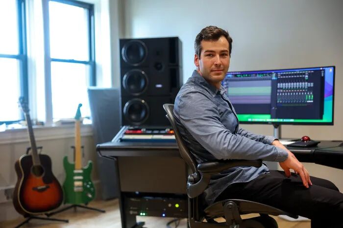 Mikey Shulman, co-founder of Suno, sits in a music studio in front of a computer monitor displaying music production software.